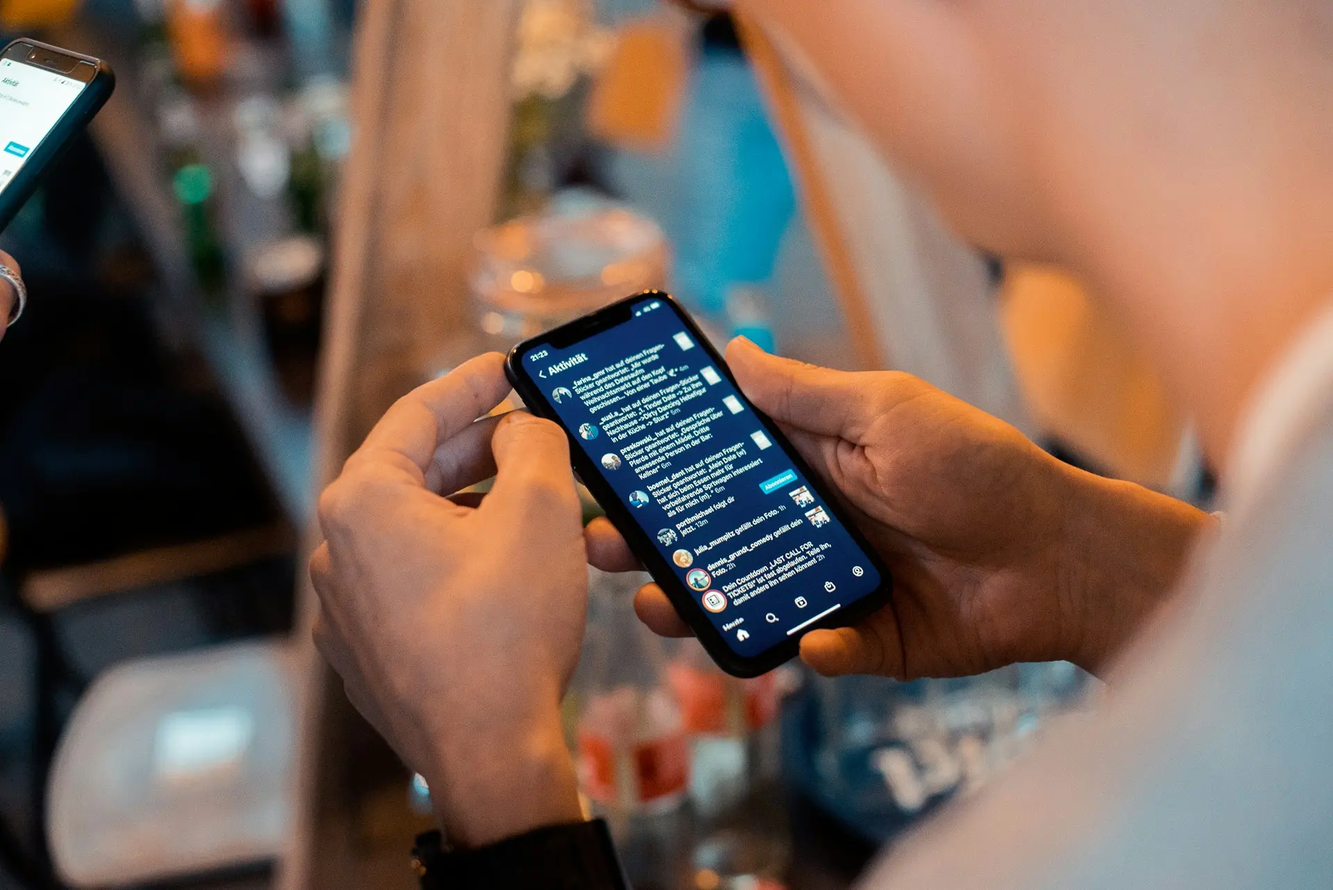 Un téléphone est tenu entre 2 mains, avec l'application Instagram ouverte sur l'écran.